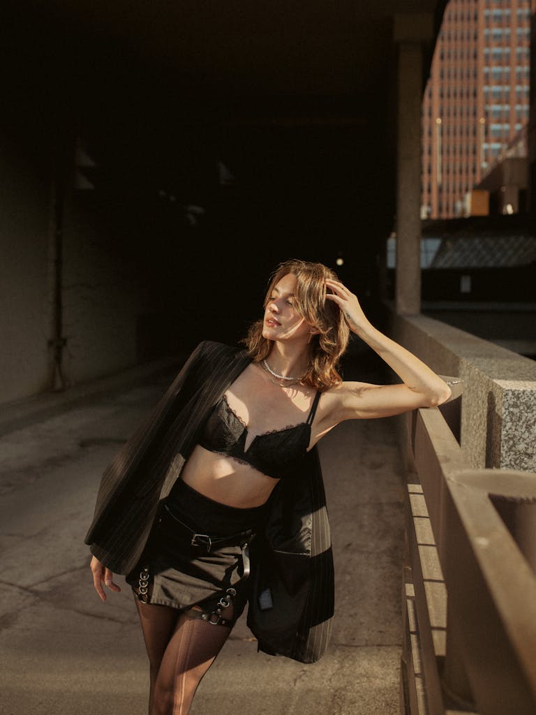 Stylish woman poses in a black bra and outfit, in a city setting, Des Moines.