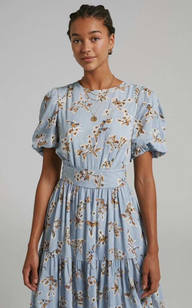 A natural-looking young woman wearing a midi dress with a defined waist and minimal accessories. Theme fashion inspo outfits