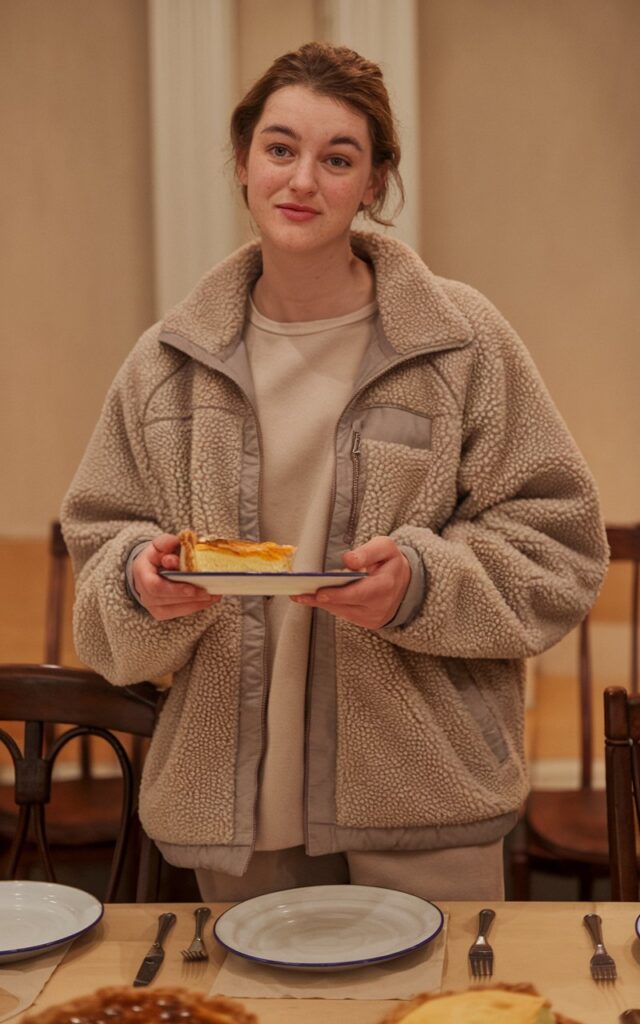 A natural-looking young woman wearing a sherpa jacket layered over a simple casual outfit. Theme thanksgiving outfit