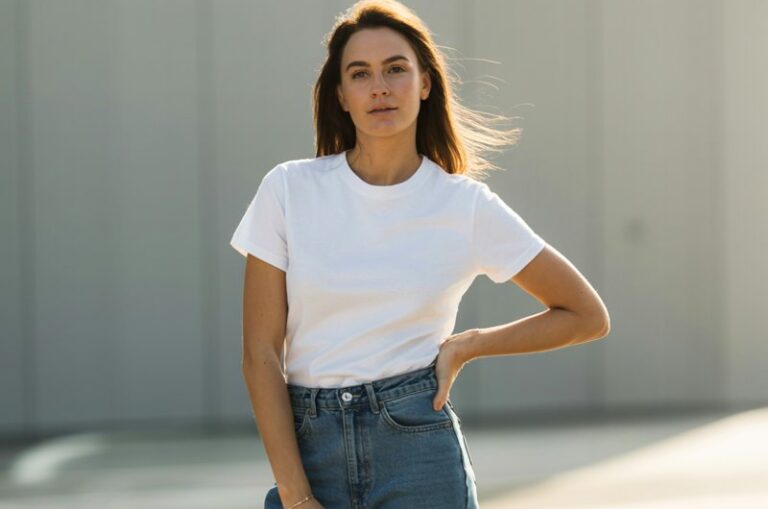 A natural-looking young woman wearing a crisp white tee paired with high-waisted straight-leg jeans and simple sneakers. Theme stylish outfits