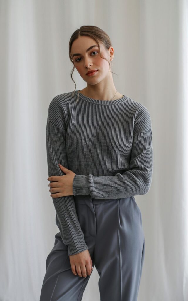A natural-looking young woman wearing a monochrome knit top matched with tailored trousers in the same color palette. Theme semi formal outfits for women