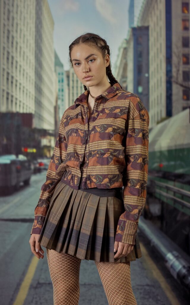 A natural-looking young woman wearing fishnet tights paired with a mini skirt. Theme 80s outfits