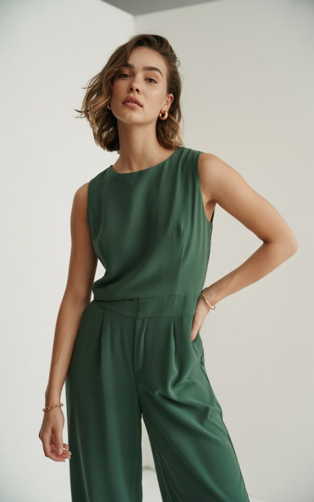 A natural-looking young woman wearing a chic jumpsuit styled with minimal accessories. Theme lookbook outfits